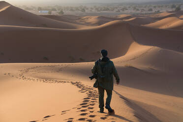 Der Fotograf wandert durch die atemberaubenden Dünen der Merzouga-Wüste (Erg Chebbi) in Marokko und fängt ihre Schönheit bei Sonnenaufgang ein, bevor er die Stadt Fes erkundet. - ADSF52936