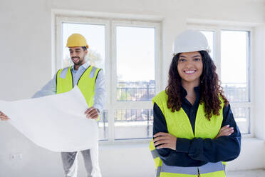 Selbstbewusster Architekt mit verschränkten Armen auf der Baustelle - AAZF01517