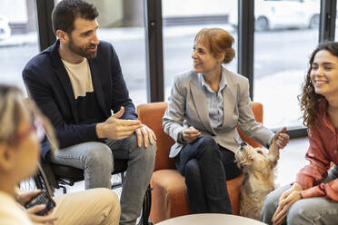 Businessman in wheelchair discussing strategy with colleagues at office - JCCMF11263