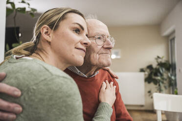 Smiling home caregiver embracing senior man - UUF31222