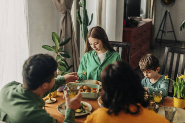 Family having meal on dining table at Easter dinner celebration - VSNF01662