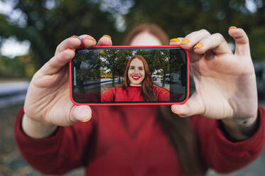 Woman taking selfie through smart phone - ALKF00975