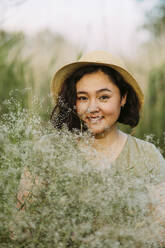 Smiling mature woman with bunch of gypsophila flowers - IEF00577