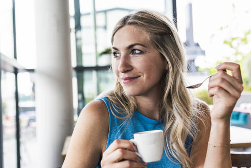 Lächelnde Frau mit Kaffeetasse im Restaurant - UUF31292