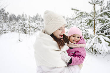 Happy mother carrying daughter at winter park - EYAF02951