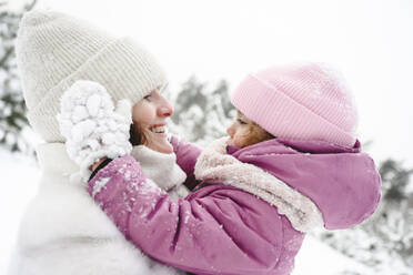 Glückliche Mutter verbringt ihre Freizeit mit ihrer Tochter im Winterpark - EYAF02956