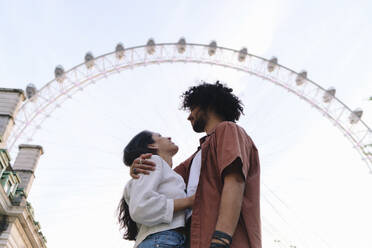 Junges Paar steht vor einem Riesenrad in London - ASGF04884