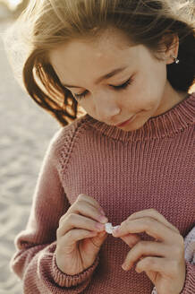 Mädchen mit Strickpulli am Strand - ALKF01034