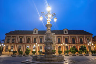 Spanien, Andalusien, Sevilla, Erzbischofspalast und Straßenlaterne Fuente Farola in der Abenddämmerung - ABOF00957