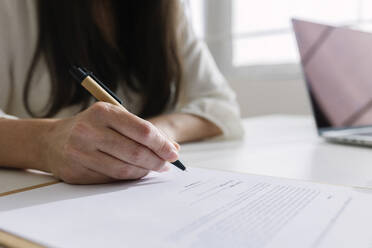 Businesswoman signing contract in office - XLGF03326