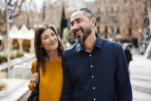 Smiling couple talking and walking on sunny day - JOSEF23465