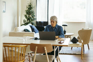 Älterer Freiberufler mit Laptop im Home Office - EBSF04365