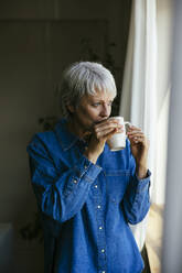 Reife Frau trinkt Kaffee zu Hause - EBSF04378
