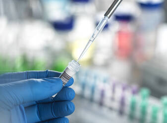 Hands of scientist pipetting DNA sample in vial at laboratory - ABRF01143