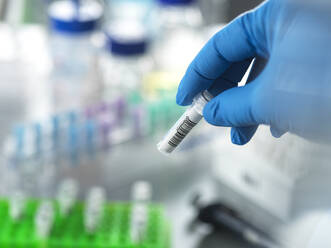 Hand of mature scientist holding DNA sample in vial at laboratory - ABRF01144