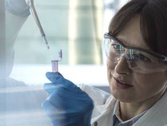Scientist pipetting DNA sample into eppendorf tube in laboratory - ABRF01148