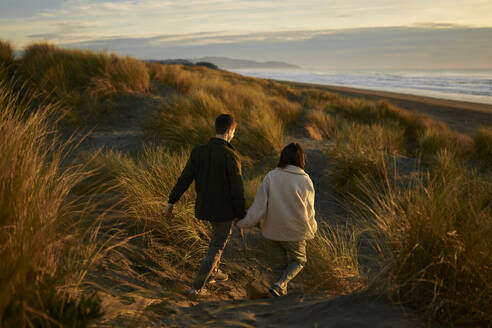 Young man and woman walking together at beach - ANNF00861