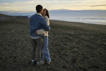 Young couple kissing at ocean beach - ANNF00882