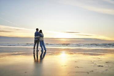 Young couple embracing at coastline on ocean beach - ANNF00887