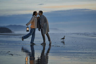 Junges Paar, das sich am Strand küsst - ANNF00918