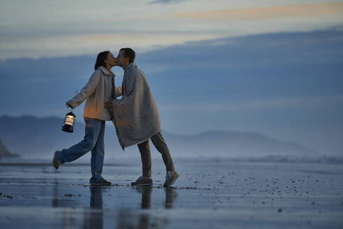 Junge Freundin und Freund küssen sich am Meeresstrand - ANNF00920