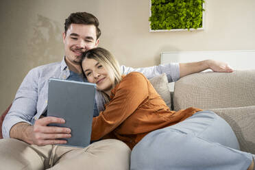 Loving young couple using tablet PC at home - UUF31338