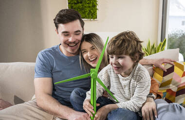 Happy family with wind turbine model at home - UUF31381