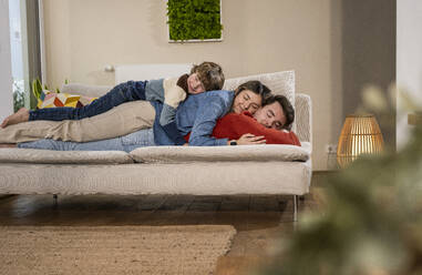 Glückliche Familie schläft auf dem Sofa zu Hause - UUF31392