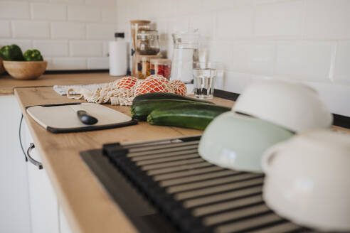 Modern kitchen counter with various food near cutting board and utensils - EBBF08776