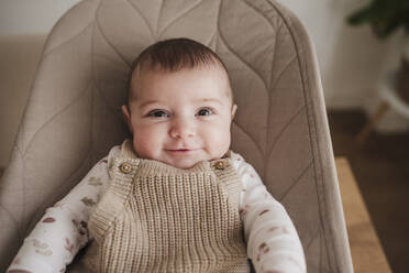 Happy baby girl sitting on bouncer chair - EBBF08782