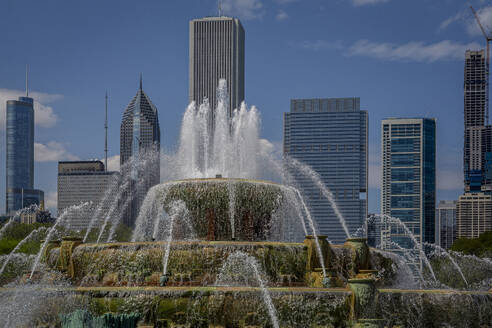 USA, Illinois, Chicago, Buckingham Fountain splashing against skyline skyscrapers - NGF00842