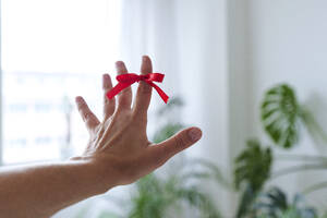 Hand einer Frau mit Mahnknoten am Zeigefinger zu Hause - AAZF01540