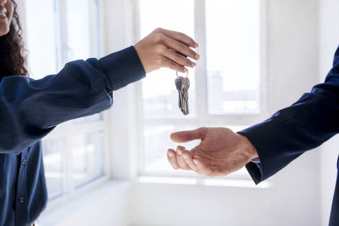 Immobilienmakler bei der Schlüsselübergabe an den neuen Eigentümer des Hauses - AAZF01573