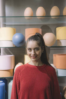 Lächelnde Frau mit rotem Pullover zu Hause - AMWF01983