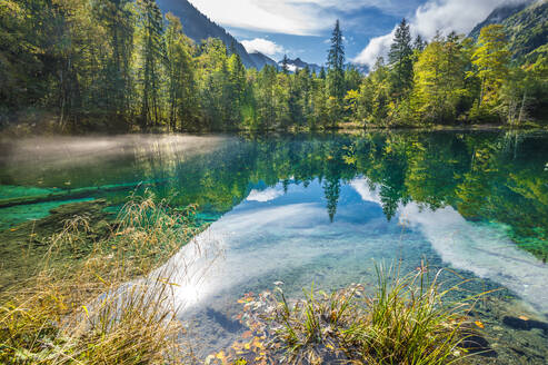 Deutschland, Bayern, Oberstdorf, Blick auf den Christlessee mit Spiegelung des umliegenden Waldes - MHF00764