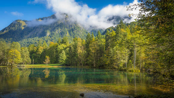 Germany, Bavaria, Oberstdorf, Scenic view of Christlessee lake with forested mountain in background - MHF00765