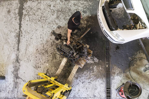 Mechaniker bei der Demontage von Fahrzeugmaschinenteilen in der Werkstatt - ASGF04890