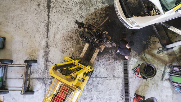 Mechaniker arbeitet in der Nähe eines Gabelstaplers in der Werkstatt - ASGF04908