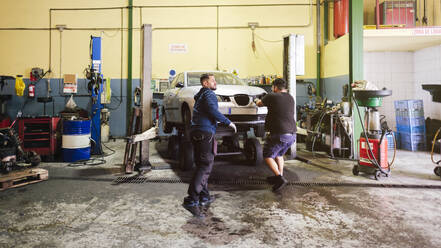 Mechanics working near car at workshop - ASGF04915