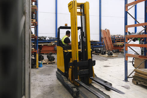 Mechaniker im Gabelstapler sitzend in der Werkstatt - ASGF04937