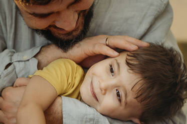 Vater streichelt den Kopf seines Sohnes zu Hause - ANAF02727