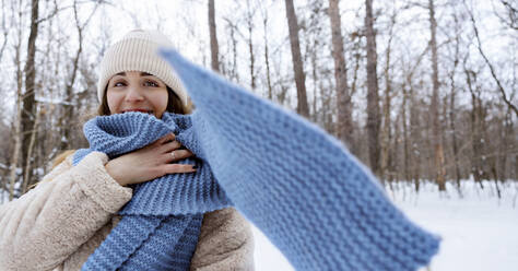 Junge Frau mit blauem Schal im Winterwald - MBLF00275