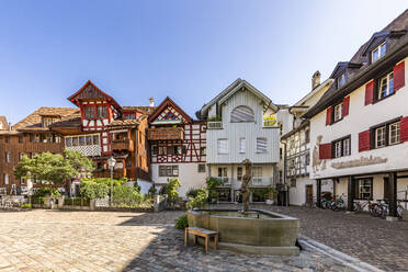 Schweiz, Thurgau, Arbon, Brunnen auf leerem Stadtplatz umgeben von historischen Häusern - WDF07528