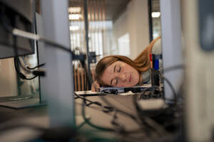 Tired businesswoman taking nap in office - JOSEF23502