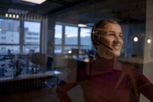 Smiling customer care representative wearing headset in office - JOSEF23544