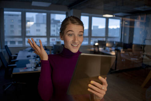 Erstaunte Geschäftsfrau bei einem Videogespräch über einen Tablet-PC im Büro - JOSEF23550