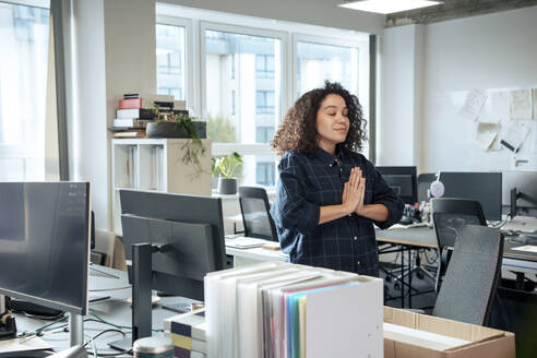 Businesswoman practicing yoga in office - JOSEF23565