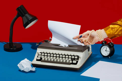 Schreiber entfernt Papier von der Schreibmaschine auf dem Schreibtisch - RDTF00011