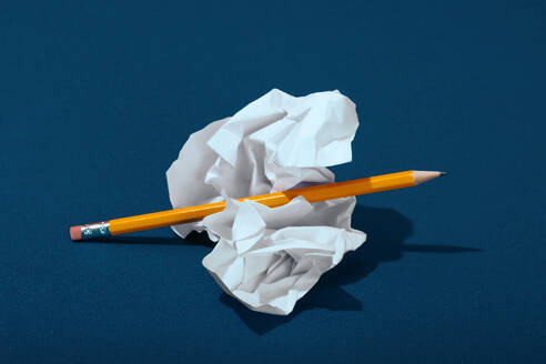 Crumpled paper with pencil on blue background - RDTF00018