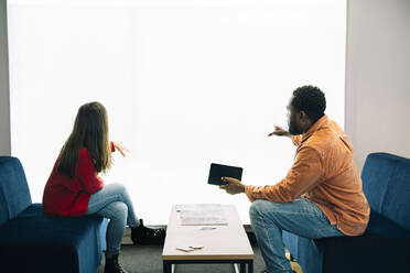 Colleagues having business meeting near projection screen at office - AMWF02041